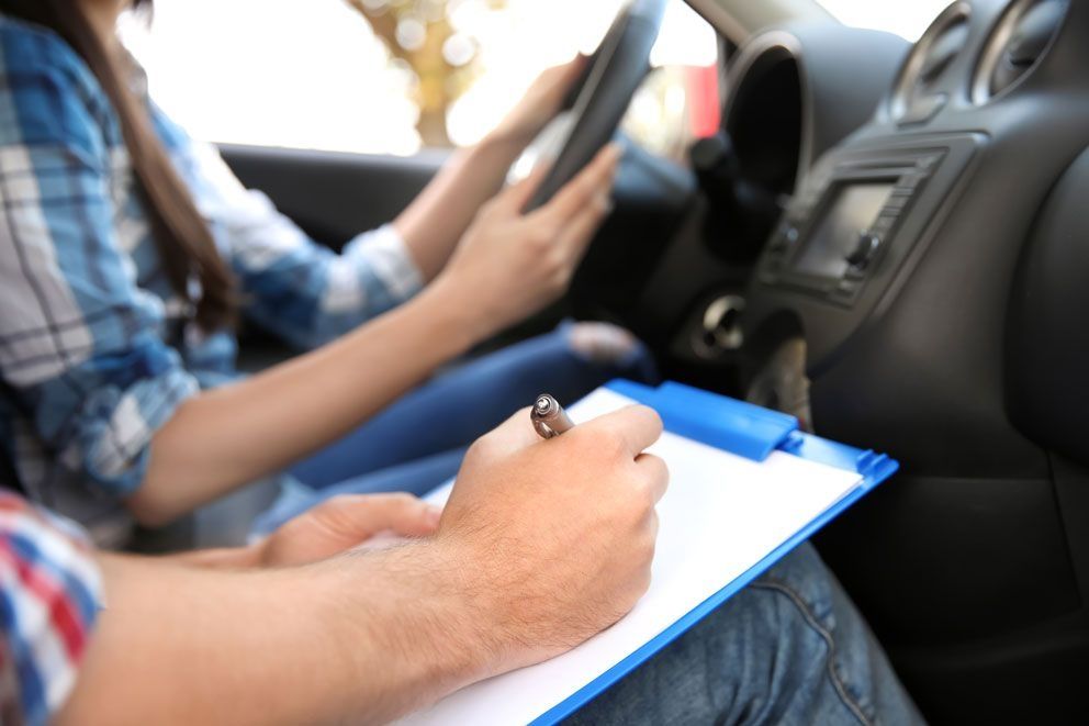 The examiner makes a note of something during the practical driving test